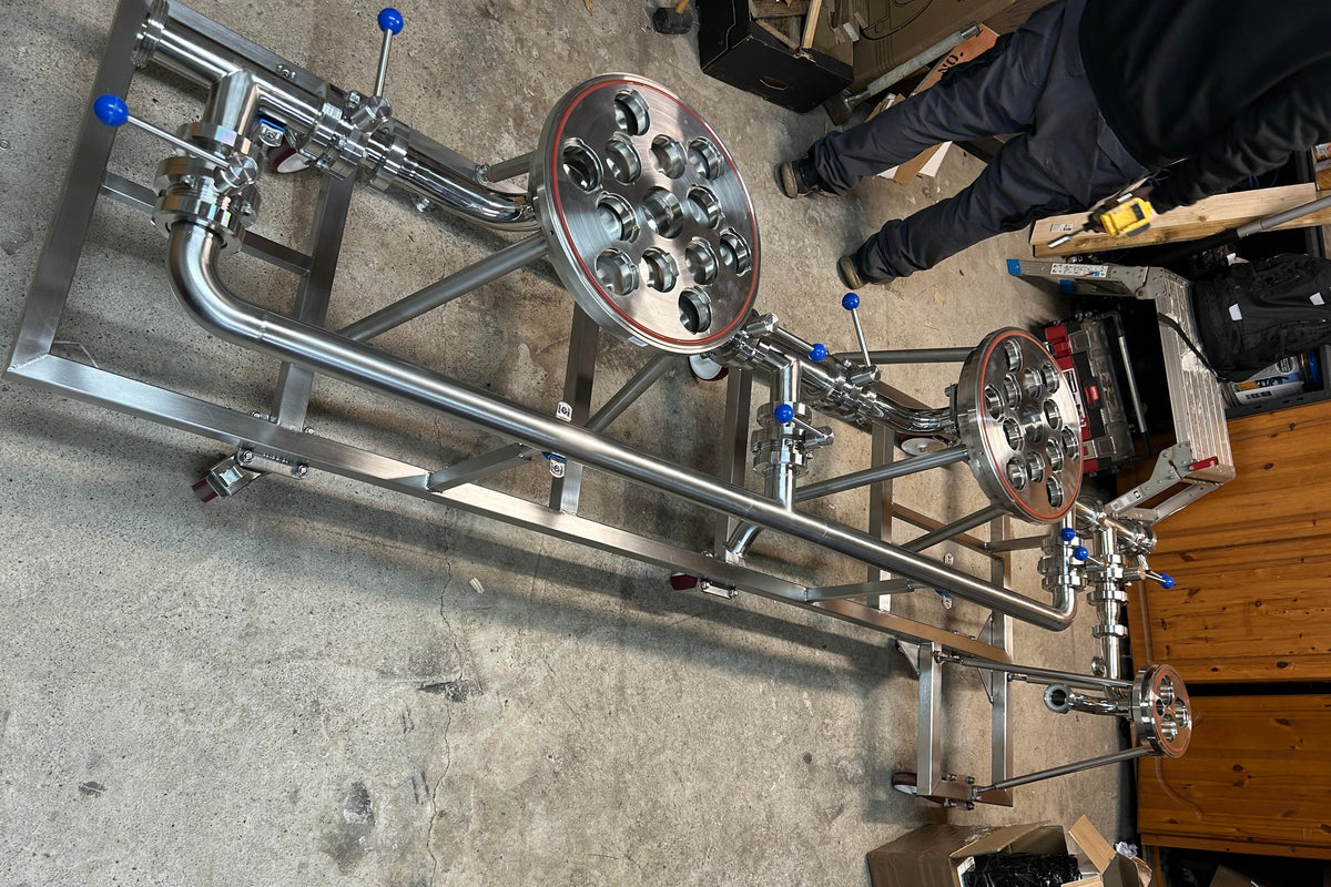 Metalworking setup with metal frames and components on a concrete floor.